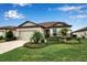 Charming single-story home with a well-manicured lawn and lush landscaping, enhancing its curb appeal at 10414 Spring Tide Way, Parrish, FL 34219