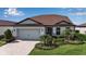 Charming single-Gathering home featuring a well-manicured lawn, lush landscaping, and a paver driveway at 10414 Spring Tide Way, Parrish, FL 34219