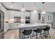 Modern kitchen featuring a large island with seating, stainless steel appliances, and stylish pendant lighting at 10414 Spring Tide Way, Parrish, FL 34219