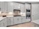 A bright kitchen shows white cabinetry, stainless appliances, tile backsplash and countertop space at 10414 Spring Tide Way, Parrish, FL 34219