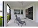 Covered lanai with serene views of the lush landscaping and sliding glass doors leading to the indoors at 10414 Spring Tide Way, Parrish, FL 34219