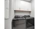 Modern laundry room equipped with high-end washer and dryer, and storage cabinets at 10414 Spring Tide Way, Parrish, FL 34219