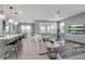 Bright living room with large windows, modern furnishings, and an open-concept design leading to the kitchen at 10414 Spring Tide Way, Parrish, FL 34219