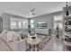 Bright and airy living room with neutral tones, plantation shutters, and a comfortable seating area at 10414 Spring Tide Way, Parrish, FL 34219