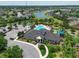 Aerial view of the community clubhouse with a pool, playground, tennis courts, and parking at 11342 77Th E St, Parrish, FL 34219