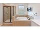 Luxurious bathroom boasts a separate shower, soaking tub, and a mounted television for relaxation at 11342 77Th E St, Parrish, FL 34219
