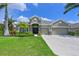 Charming single-story home with well-manicured lawn, mature landscaping, and three-car garage at 11342 77Th E St, Parrish, FL 34219