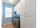 Well-organized laundry room features ample white cabinets and a modern washer and dryer set at 11342 77Th E St, Parrish, FL 34219