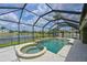 Screened-in pool with spa, lake view, and ample lounging space under a bright blue sky at 11342 77Th E St, Parrish, FL 34219