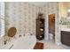 Bathroom featuring an ornate mirror above a bathtub and patterned wallpaper throughout at 12240 Thornhill Ct, Lakewood Ranch, FL 34202