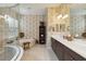 Elegant bathroom features a soaking tub, separate glass shower, dual sinks, and decorative wallpaper at 12240 Thornhill Ct, Lakewood Ranch, FL 34202