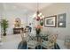 Bright dining area with a glass table, neutral walls, and a view into the living room at 12240 Thornhill Ct, Lakewood Ranch, FL 34202