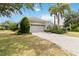 Inviting one-story home with a paved driveway, well-maintained lawn, and lush tropical landscaping at 12240 Thornhill Ct, Lakewood Ranch, FL 34202