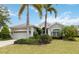 Inviting single story home with a lush green lawn, palm trees, and a welcoming entrance at 12240 Thornhill Ct, Lakewood Ranch, FL 34202