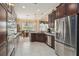 Modern kitchen with dark wood cabinets, stainless steel appliances, granite countertops, and a large window overlooking the yard at 12240 Thornhill Ct, Lakewood Ranch, FL 34202