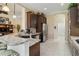 Modern kitchen featuring granite countertops, stainless steel appliances, dark cabinets, and a breakfast bar at 12240 Thornhill Ct, Lakewood Ranch, FL 34202