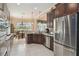 Spacious kitchen with dark wood cabinets, stainless steel appliances, and a view of the eat-in kitchen at 12240 Thornhill Ct, Lakewood Ranch, FL 34202