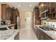Spacious kitchen with stainless steel appliances, granite counters, tile flooring, and dark wood cabinetry at 12240 Thornhill Ct, Lakewood Ranch, FL 34202