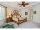 Bright main bedroom featuring large windows, a decorative ceiling fan, and a wooden bed frame at 12240 Thornhill Ct, Lakewood Ranch, FL 34202