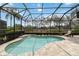 Beautiful in-ground swimming pool inside a screen enclosure, surrounded by lush landscaping at 12240 Thornhill Ct, Lakewood Ranch, FL 34202