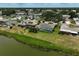 Aerial view featuring a screened-in pool and lake view, surrounded by lush green landscaping at 1227 Waterside Ln, Venice, FL 34285