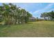 Lush backyard featuring a screened-in patio with tropical landscaping at 1227 Waterside Ln, Venice, FL 34285