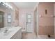 Clean pink bathroom featuring a shower, sink, vanity, toilet, and framed mirror at 1227 Waterside Ln, Venice, FL 34285