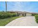 Attractive single-story home with stone accents, a wide driveway, and lush green landscaping at 1227 Waterside Ln, Venice, FL 34285