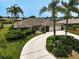 Aerial view of the home featuring a concrete driveway and lush, manicured landscaping at 1227 Waterside Ln, Venice, FL 34285