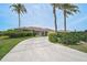 Inviting single-story home features tropical landscaping and a curved driveway leading to an attached two-car garage at 1227 Waterside Ln, Venice, FL 34285