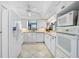 Bright kitchen with white appliances, white cabinets, and tile flooring at 1227 Waterside Ln, Venice, FL 34285
