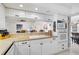 Bright, modern kitchen features white cabinets, tile countertops, and stainless steel appliances at 1227 Waterside Ln, Venice, FL 34285