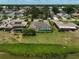 Aerial view of a home with a screened-in pool and a spacious green lawn at 1227 Waterside Ln, Venice, FL 34285