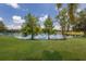 Scenic backyard view featuring a tranquil lake and well-maintained green lawn at 13706 American Prairie Pl, Lakewood Ranch, FL 34211