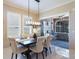 Bright dining area with modern lighting, seating for six, and seamless flow to screened outdoor kitchen at 13706 American Prairie Pl, Lakewood Ranch, FL 34211
