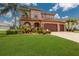 Charming two-story home featuring a three-car garage, tile roof, and manicured lawn at 13706 American Prairie Pl, Lakewood Ranch, FL 34211