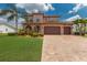 Charming two-story home featuring a three-car garage, tile roof, well-manicured lawn and a brick driveway at 13706 American Prairie Pl, Lakewood Ranch, FL 34211