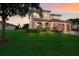 Beautifully landscaped front yard with palm trees and a charming Mediterranean-style home at 13706 American Prairie Pl, Lakewood Ranch, FL 34211