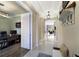 Hallway with white tile floors leads to a home office and other living spaces providing a spacious and airy feel at 13706 American Prairie Pl, Lakewood Ranch, FL 34211