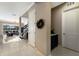 A hallway features tile floors, a wreath and bar area, leading to a living space with a staircase and a view at 13706 American Prairie Pl, Lakewood Ranch, FL 34211