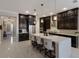 Modern kitchen features stainless steel appliances, a large island with seating, and dark wood cabinetry at 13706 American Prairie Pl, Lakewood Ranch, FL 34211