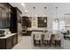 Bright kitchen with large island and seating features stainless appliances, dark cabinetry, and pendant lighting at 13706 American Prairie Pl, Lakewood Ranch, FL 34211