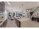 Open-concept kitchen features a large marble island, pendant lighting, and seamless flow to the outdoor living area at 13706 American Prairie Pl, Lakewood Ranch, FL 34211