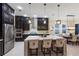 Contemporary kitchen with stainless steel appliances, a large island, and sleek dark cabinetry at 13706 American Prairie Pl, Lakewood Ranch, FL 34211