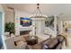 Comfortable living area with fireplace, custom mantle, elegant lighting, and convenient access to stairs at 13706 American Prairie Pl, Lakewood Ranch, FL 34211