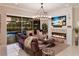 Inviting living room with a modern fireplace, comfortable seating, and sliding glass doors to the screened-in pool at 13706 American Prairie Pl, Lakewood Ranch, FL 34211