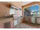 Outdoor kitchen offering a stainless steel grill, sink, hood and mini fridge with paver flooring at 13706 American Prairie Pl, Lakewood Ranch, FL 34211