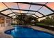 Spacious screened-in pool area with a connecting spa, an outdoor kitchen, and stunning sunset views at 13706 American Prairie Pl, Lakewood Ranch, FL 34211