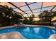 Sparkling screened-in pool featuring a connecting spa, a basketball hoop, and a backdrop of swaying palms at 13706 American Prairie Pl, Lakewood Ranch, FL 34211