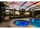 Enclosed pool with a spa and lounge area overlooking a pond surrounded by tall palm trees at 13706 American Prairie Pl, Lakewood Ranch, FL 34211